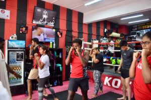 A boxing class diligently practicing their boxing stances at KOS.