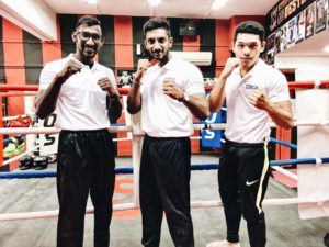 KOS coaches standing in a powerful pose, Coach Krishna, Coach Kumar, and Coach Khai