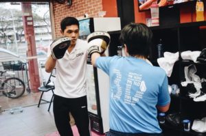 Coach Khai in a one-on-one sparring session, blocking student's punches