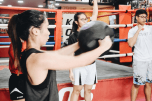 Focused Female Boxer Following Instructions in Class
